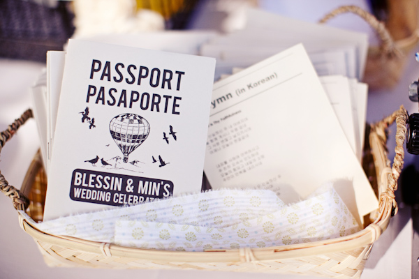 Wedding programs decorated with a helium balloon and birds and hymn lyrics in a wicker basket - by San Francisco based wedding photographer Meg Perotti